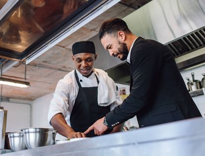 Chef and restaurant manager prepping food together