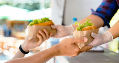 Customer receiving their order through a food truck window