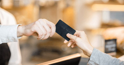 Customer handing a restaurant employee a black payment card