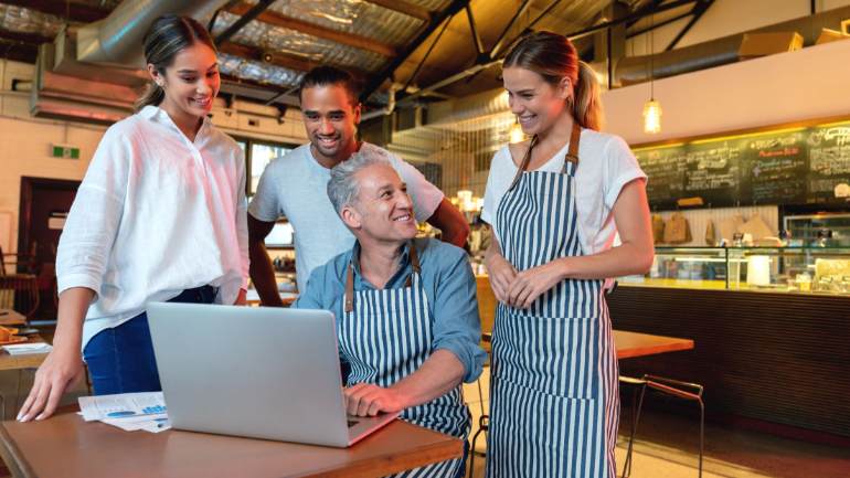 Restaurant staff gathered around a laptop