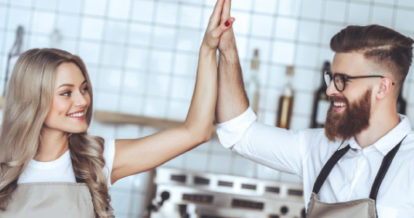 2 restaurant employees giving each other a high five