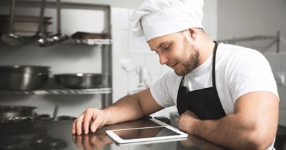 chef using iPad POS in restaurant kitchen