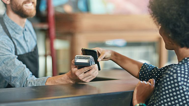 A woman making payment via NFC mobile phone