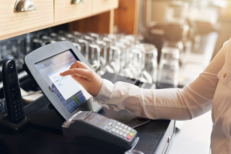 Waitress using a POS system to process payments in a restaurant