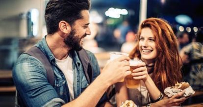 Two people clinking their beer glasses together