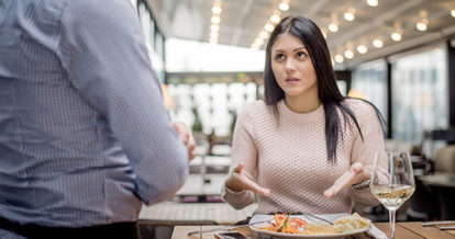 Customer looking dissatisfied with her plate of food in front of restaurant employee