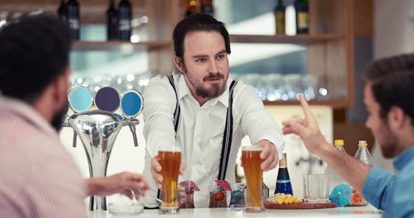 Bartender serving beers to customers at the bar