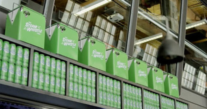 Shelf filled with Steam Whistle beer cans and products