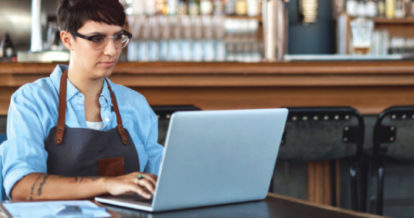 Restaurant employee working on laptop in a restaurant