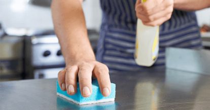 Man scrubbing a kitchen surface with a sponge