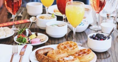 Restaurant table with a variety of dishes and drinks for brunch