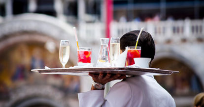 Server carrying a large tray of drinks