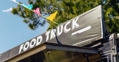 The word food truck displayed on top of a food truck.