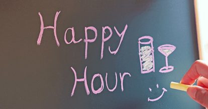 Happy hour written on a chalkboard