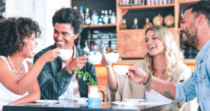 Friends around a cafe table having tea and coffee