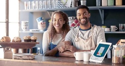 restaurant owners smiling behind the counter of their shop