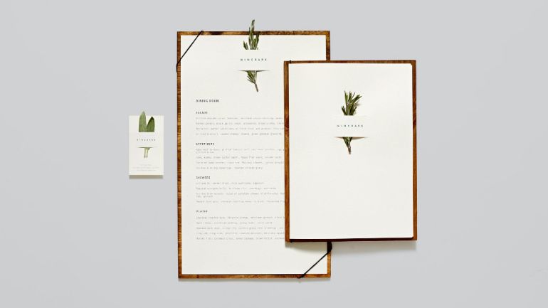A menu with an herb tucked at the top