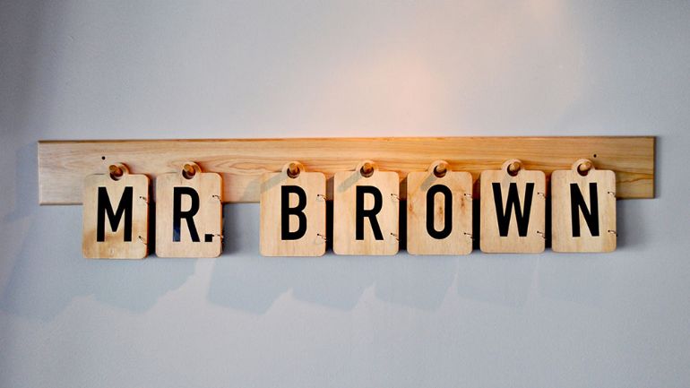 Menus hung on the wall form the word "Mr. Brown"