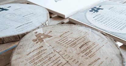 A menu etched into a log of wood