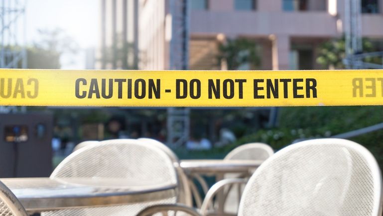 Caution tape around a patio table after a patron leaves without paying.