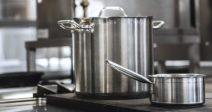 Two stainless steel pots in a commercial kitchen
