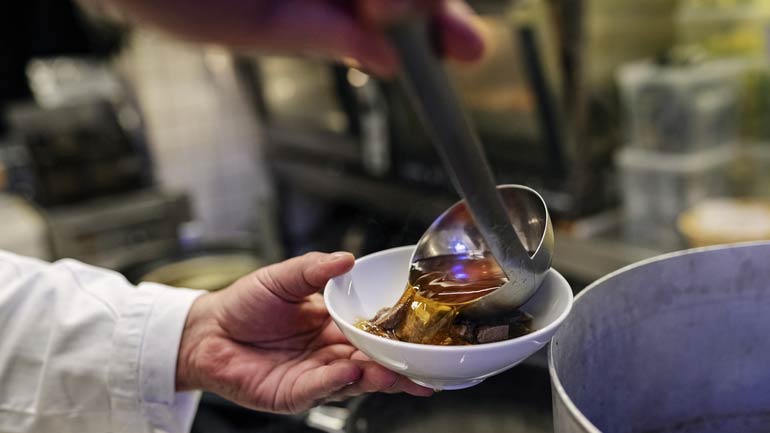 Soup being ladled into a bowl