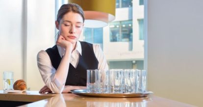 Sleepy server resting chin on hand