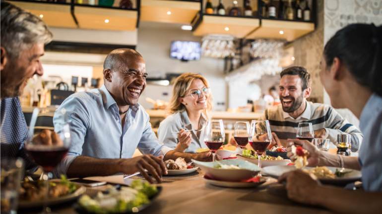 Coworkers having lunch at a restaurant and laughing together