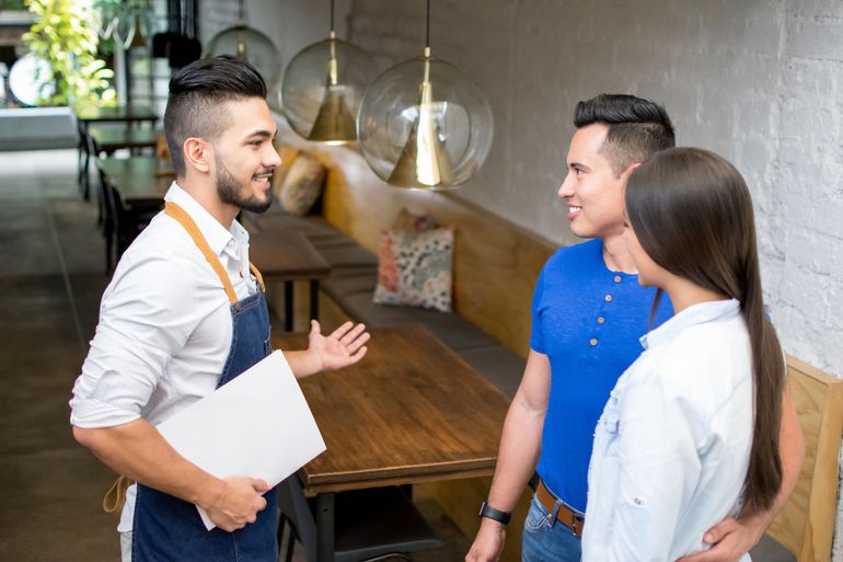 A waiter helping a couple find a walk-in seat