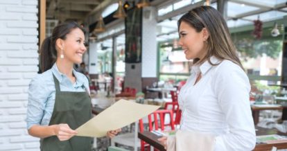 Two waitresses talking in front of the restaurant
