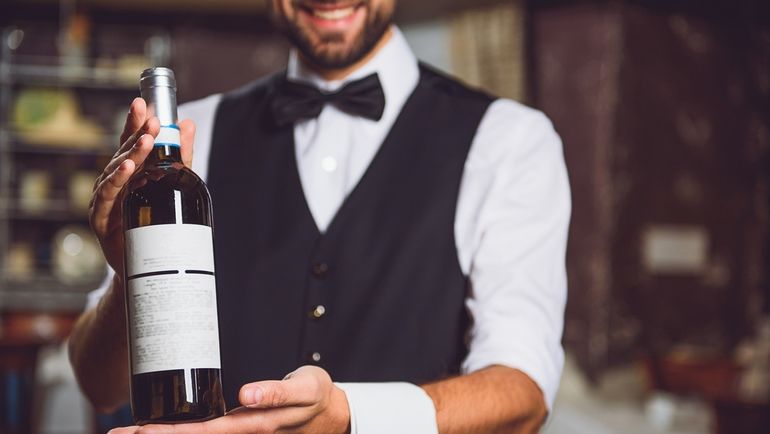 A waiter presenting a bottle of wine