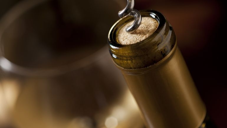 A bottle of wine being uncorked