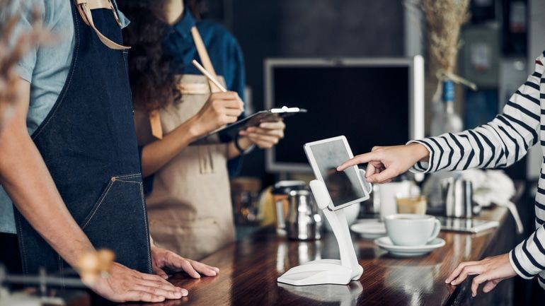 Customer ordering at a cafe using a self-service tablet screen