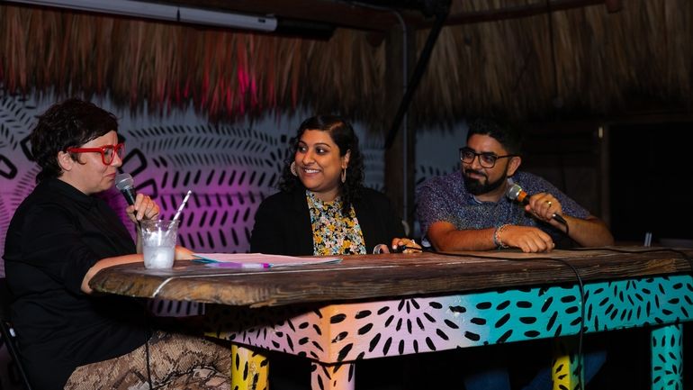 Niven and Shivani Patel sitting at table on stage smiling as they are interviewed at the Miami Industry Sessions