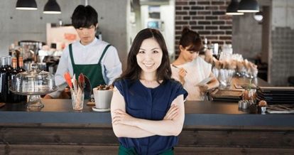 Manager smiling in front of cafe counter