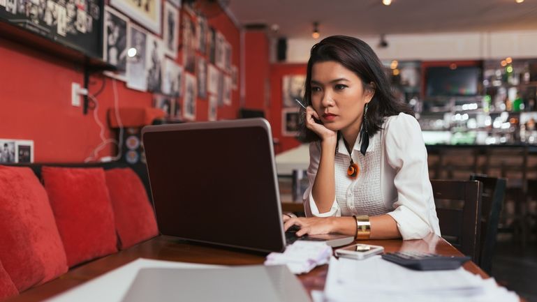 A woman in a restaurant on a laptop