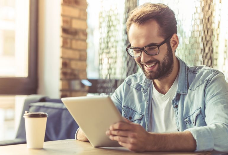 A man smiling at his iPad