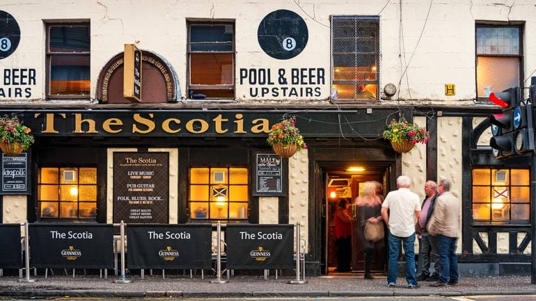 Patrons standing in front of a pub