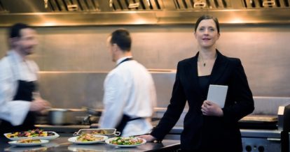 Restaurant manager standing in busy kitchen