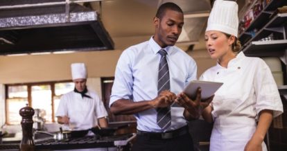 restaurant manager reviewing POS with kitchen staff