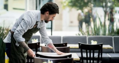 Server wiping table in empty restaurant