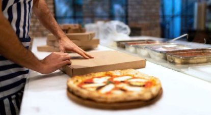 pizza being prepped for take away