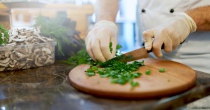 chef chopping herbs wearing gloves