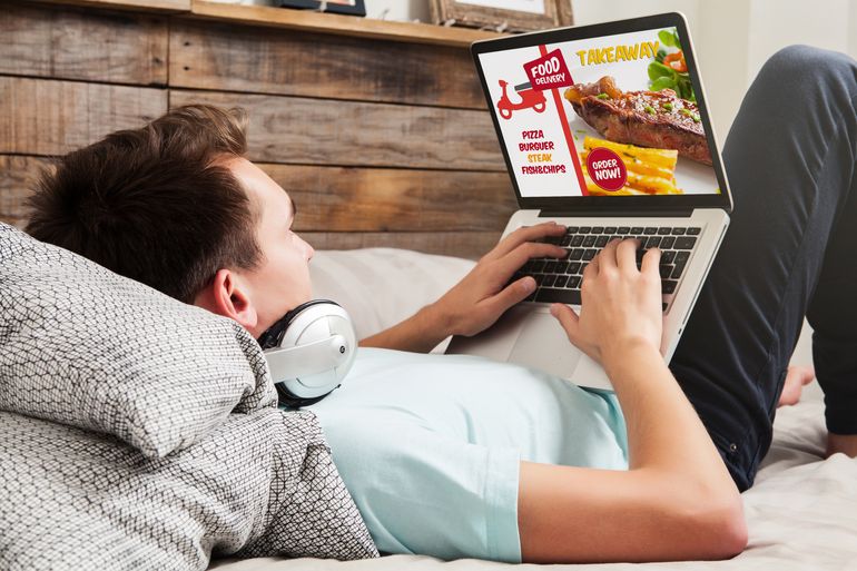 Man with headphones places an online ordering from a restaurant