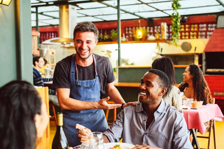 A waiter greeting his restaurant guests