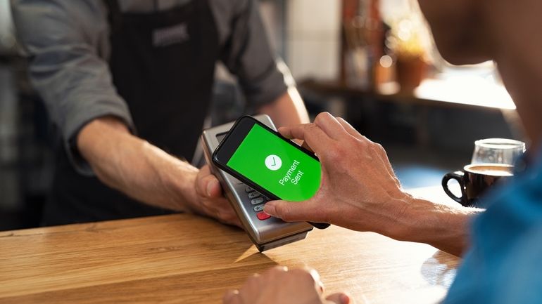 Customer using contactless payments to purchase a coffee