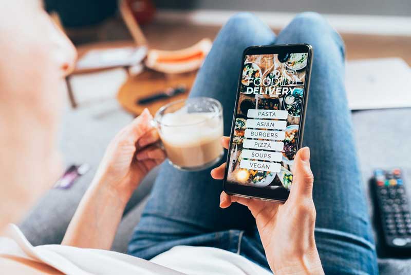 A woman ordering food from an app on her phone