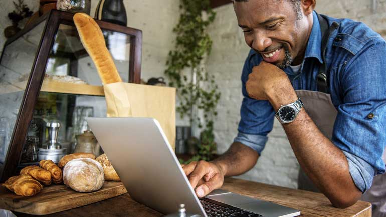 A restaurant owner looking at his TouchBistro POS and smiling