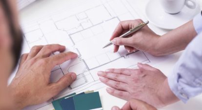 restaurateurs reviewing floor plan on blueprint