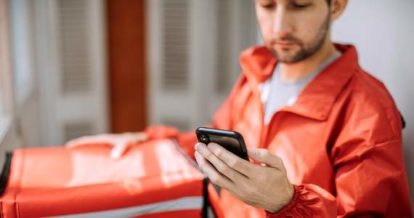 Delivery driver looking for an address on his phone